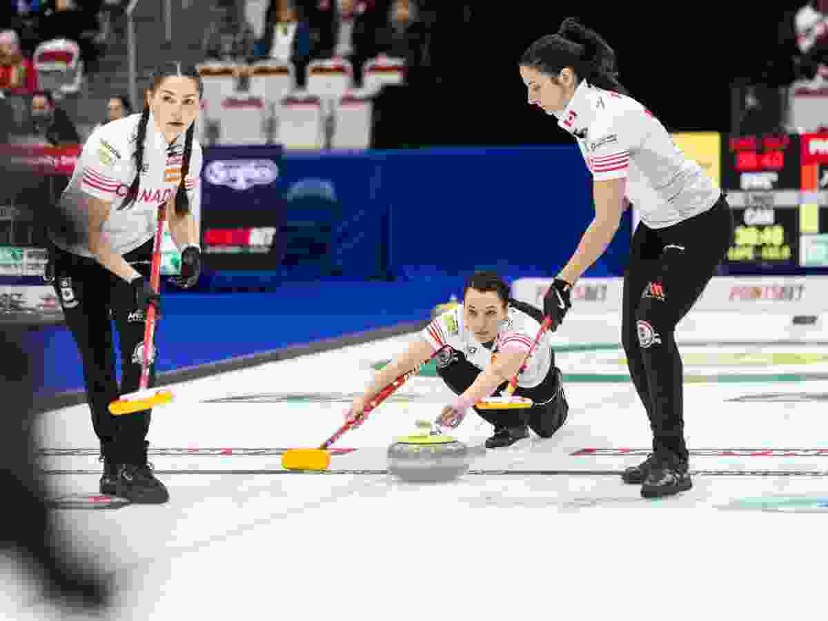 Team Canada third Val Sweeting throws to lead Karlee Burgess and second Shannon Birchard in the opening round against Sweden for the BKT World Women's Curling championship at Winsport Calgary