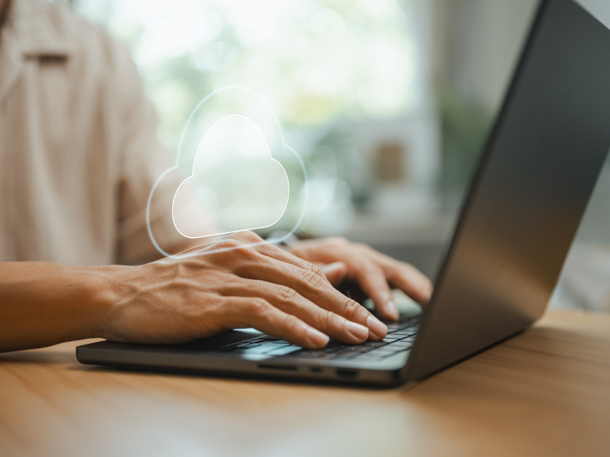 Professional uses cloud computing on a laptop to securely store, sync, and access business data online.