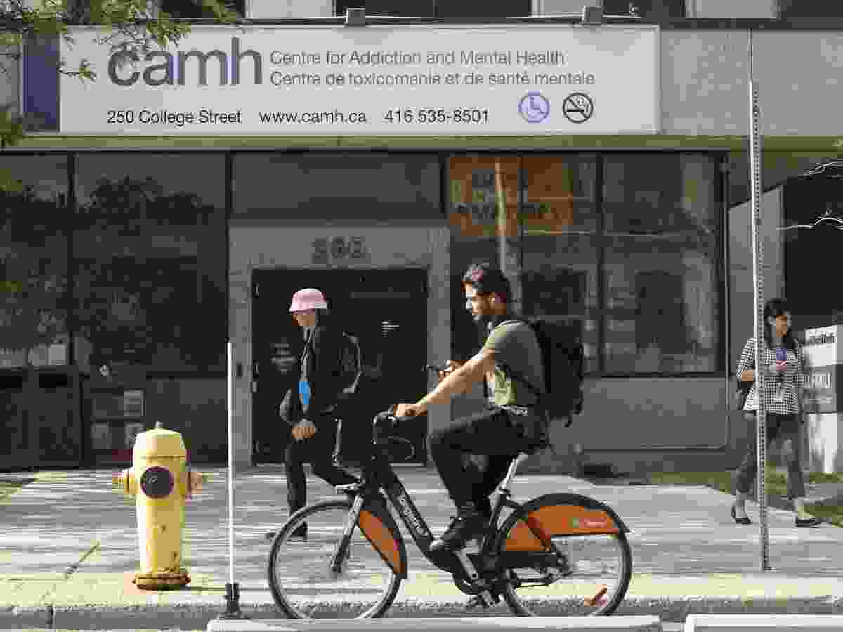 A man bicycles past CAMH