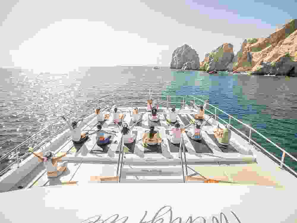 Morning yoga on the Sea of Cortez, with the iconic Arch of Los Cabos in the background.