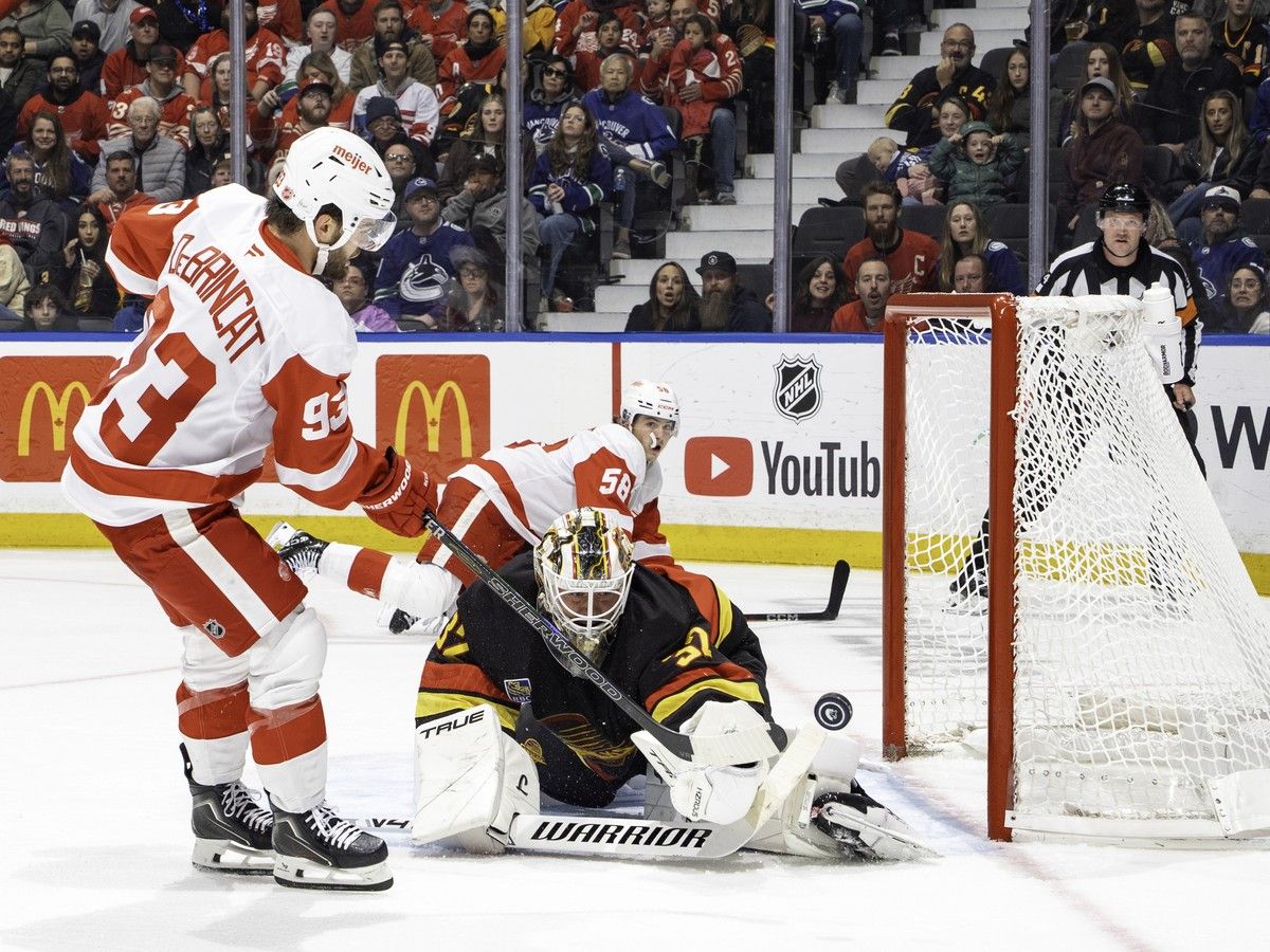 Alex DeBrincat of the Detroit Red Wings takes a shot on Vancouver Canucks goalie Kevin Lankinen during the third period at Rogers Arena on Thursday night. The Red Wings won 5-2.