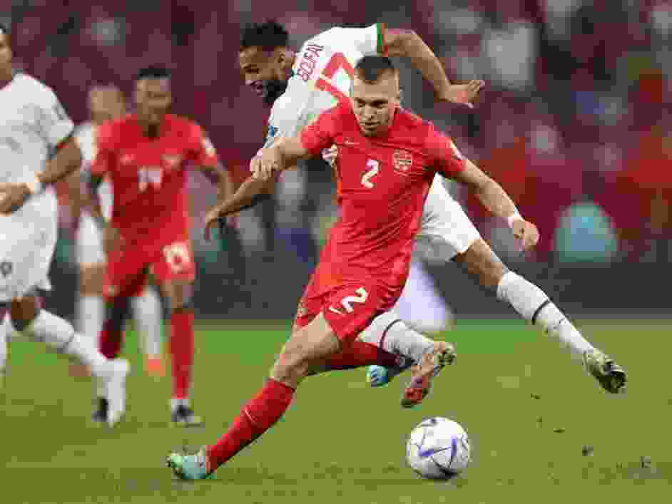 Alistair Johnston of Canada holds off Sofiane Boufal of Morocco during the FIFA World Cup Qatar 2022 Group F match at Al Thumama Stadium on December 01, 2022 in Doha, Qatar.