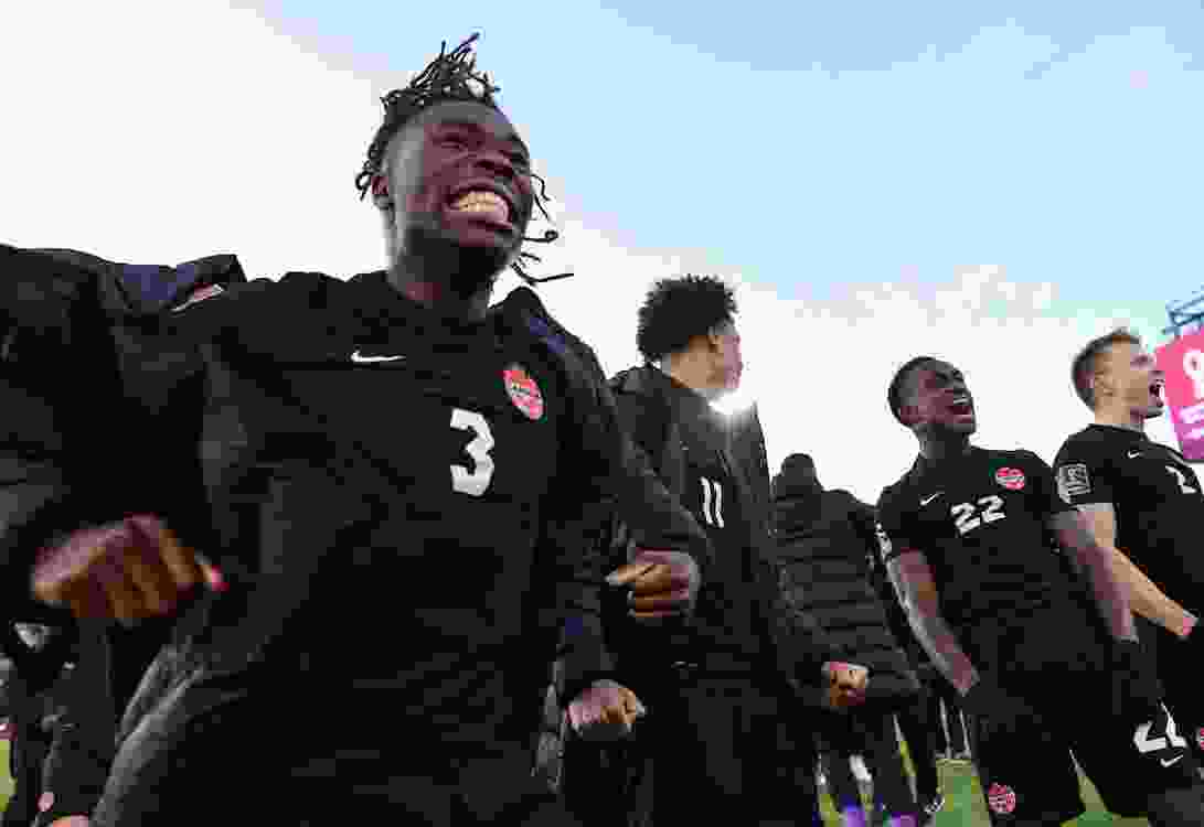 Sam Adekugbe, left, and Richie Laryea, 22, celebrate Canada's victory over the U.S. in the FIFA World Cup Qualifiers in Hamilton in January 2022. Both were disappointed that the coach who'd help get them to the World Cup, John Herdman, had left the national team to coach Toronto FC.