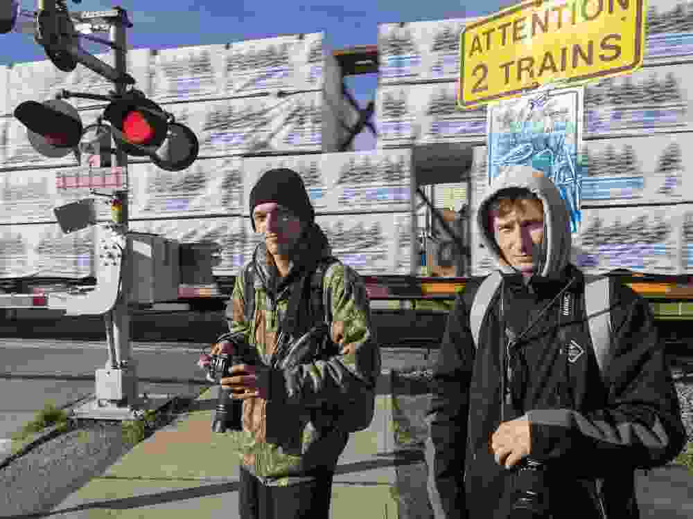 Justin Camp, 22, and Brody Daniel, 23, are train spotters who were watching as a CN Rail freight train passed through Ingersoll on Monday, Nov. 18, 2024. (Mike Hensen/The London Free Press)