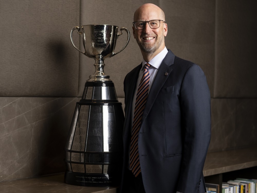 CFL commissioner Stewart Johnston poses with the Grey Cup.