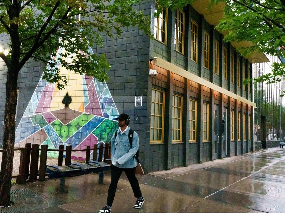 A man walks by the Our Window mural by AJA Louden at the Downtown Calgary Mosque on Tuesday.