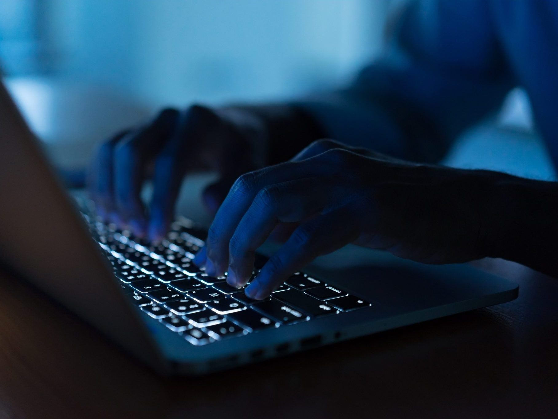 close up programmer man hand typing on keyboard laptop for register data system or access password at dark operation room , cyber security concept