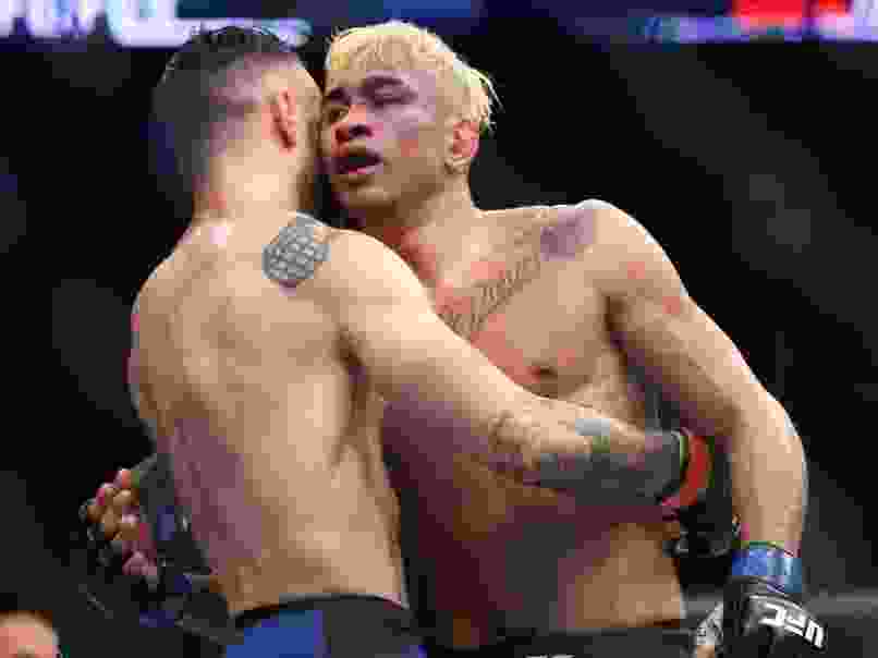 Shane Burgos (L) and Godofredo Pepey (R) hug at the end of their UFC Fight Night featherweight bout at the Nassau Veterans Memorial Coliseum on July 22, 2017 in Uniondale, New York.