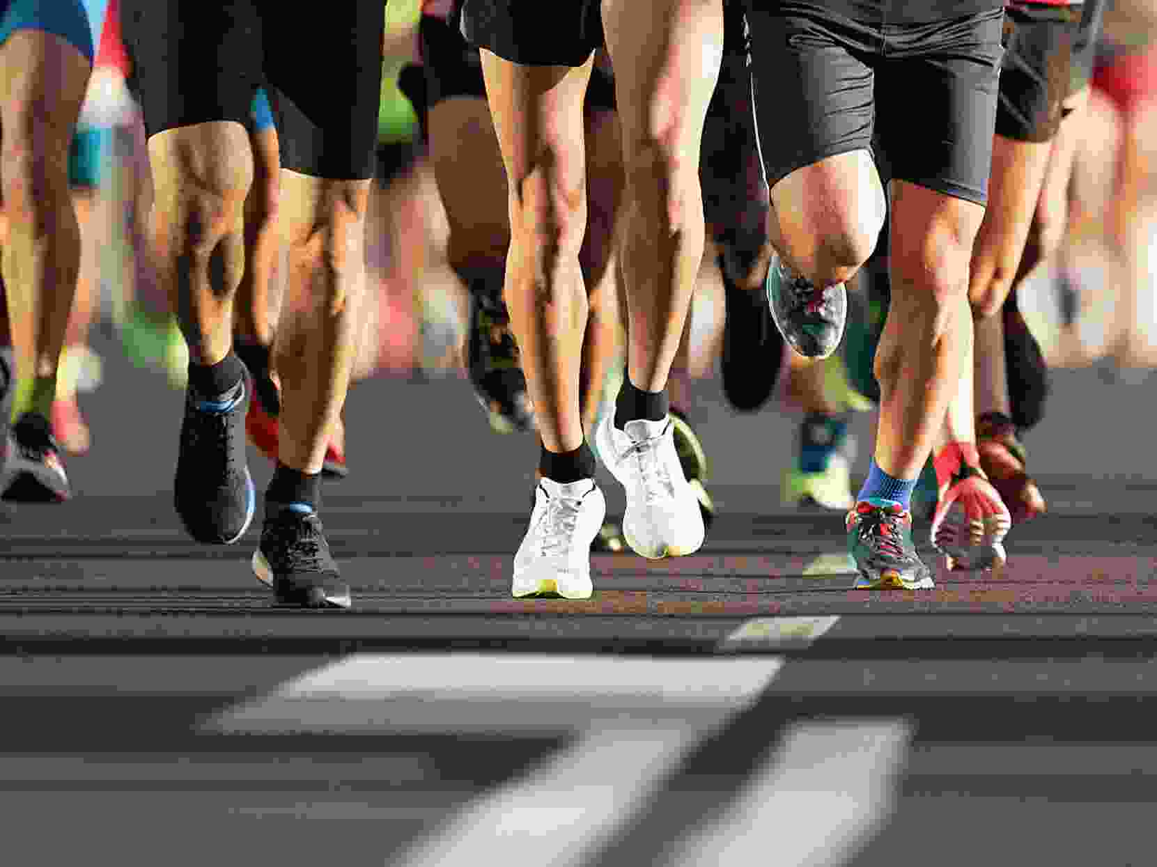 Marathon runners running on city road, large group of runners