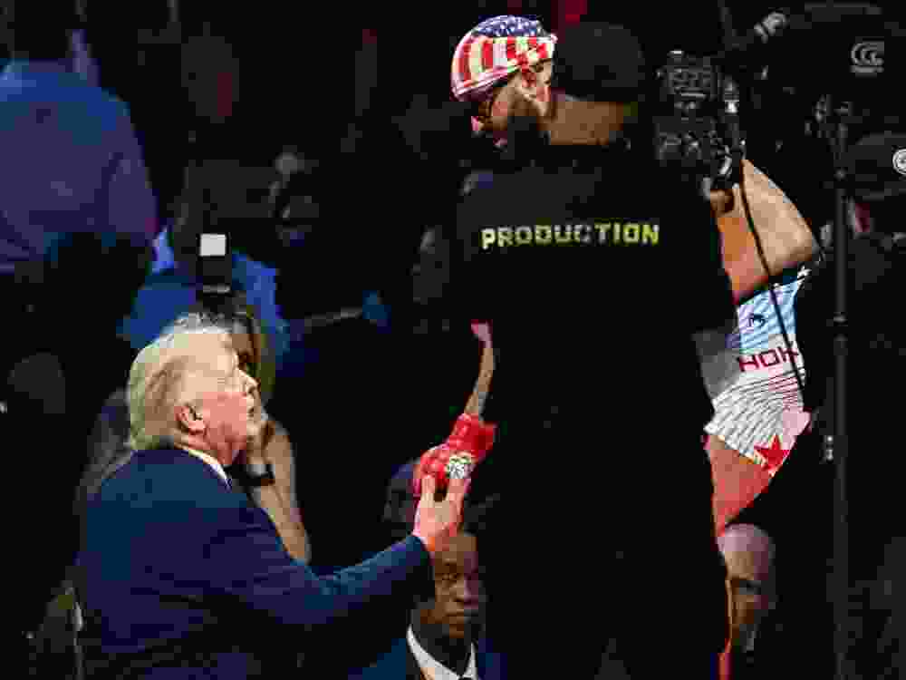 US President Donald Trump shakes hands with fighter Josh Hokit during the UFC Freedom 250 event.