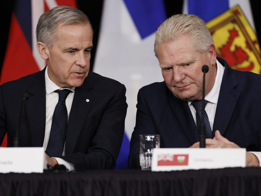 Canada's Prime Minister Mark Carney speaks to Ontario Premier Doug Ford during a press conference following a First Ministers Meeting in Ottawa on Jan. 29, 2026.