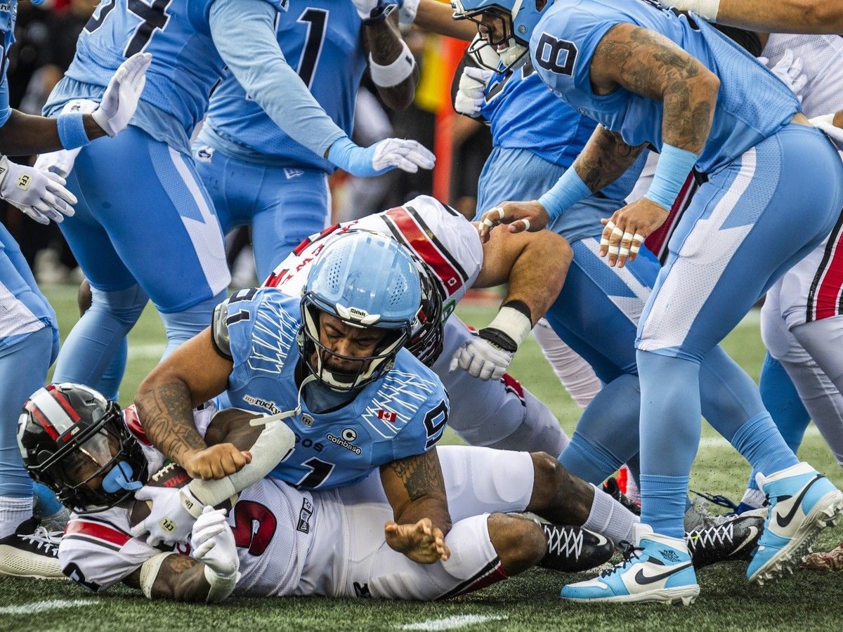 The Ottawa Redblacks' Greg Bell battles to keep the ball from the Toronto Argonauts during the first half of the game on Saturday.