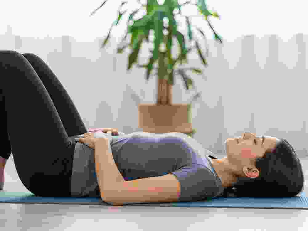 Person lying on back performing pelvic floor exercises
