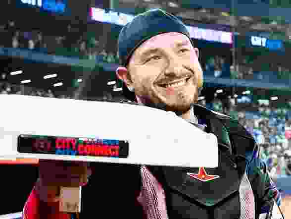 Alejandro Kirk #30 of the Toronto Blue Jays smiles while holding the base to celebrate his first major league stolen base following his team's win over the Texas Rangers in their MLB game at the Rogers Centre on August 15, 2025 in Toronto, Ontario, Canada.