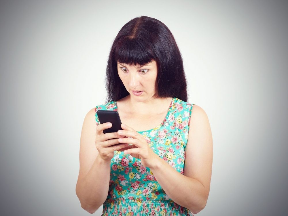 A woman looks at her phone.