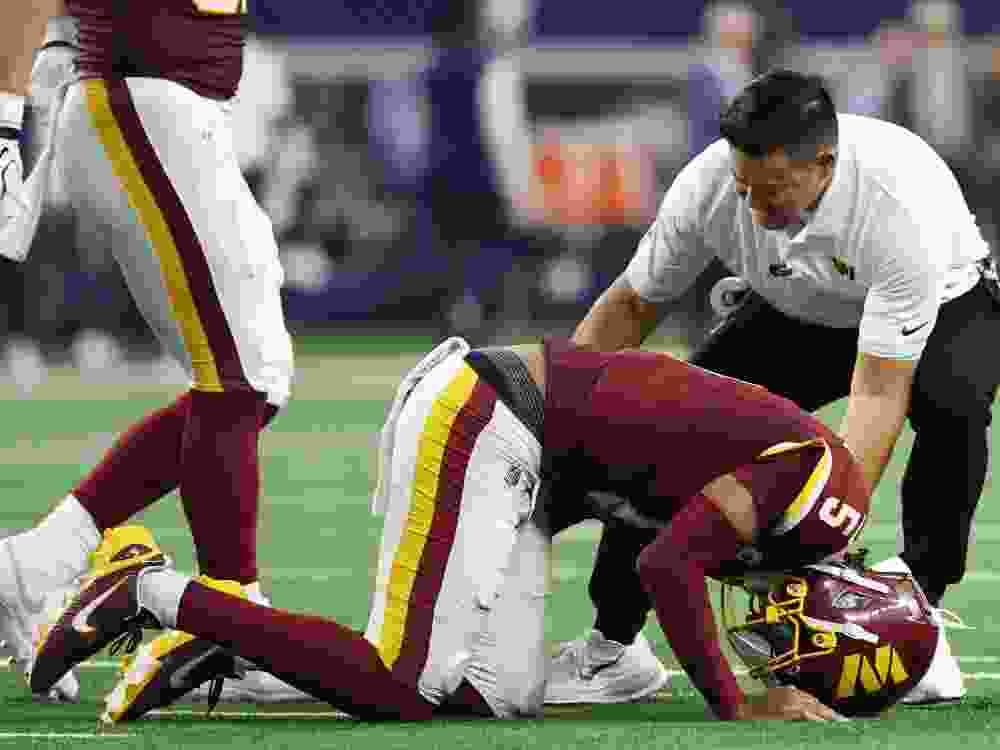 A member of the Washington Commanders medical staff attends to quarterback Jayden Daniels after he sustained an injury against the Dallas Cowboys.