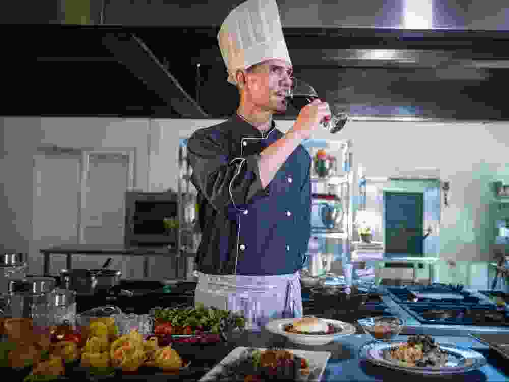 A chef with a glass of wine