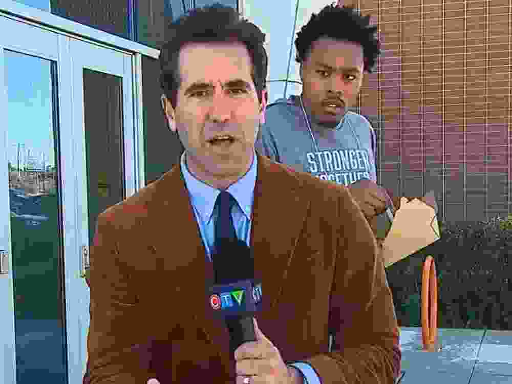 Toronto Raptors' Scottie Barnes stands behind CTV News reporter Sean Leathong during a live report on Thursday.