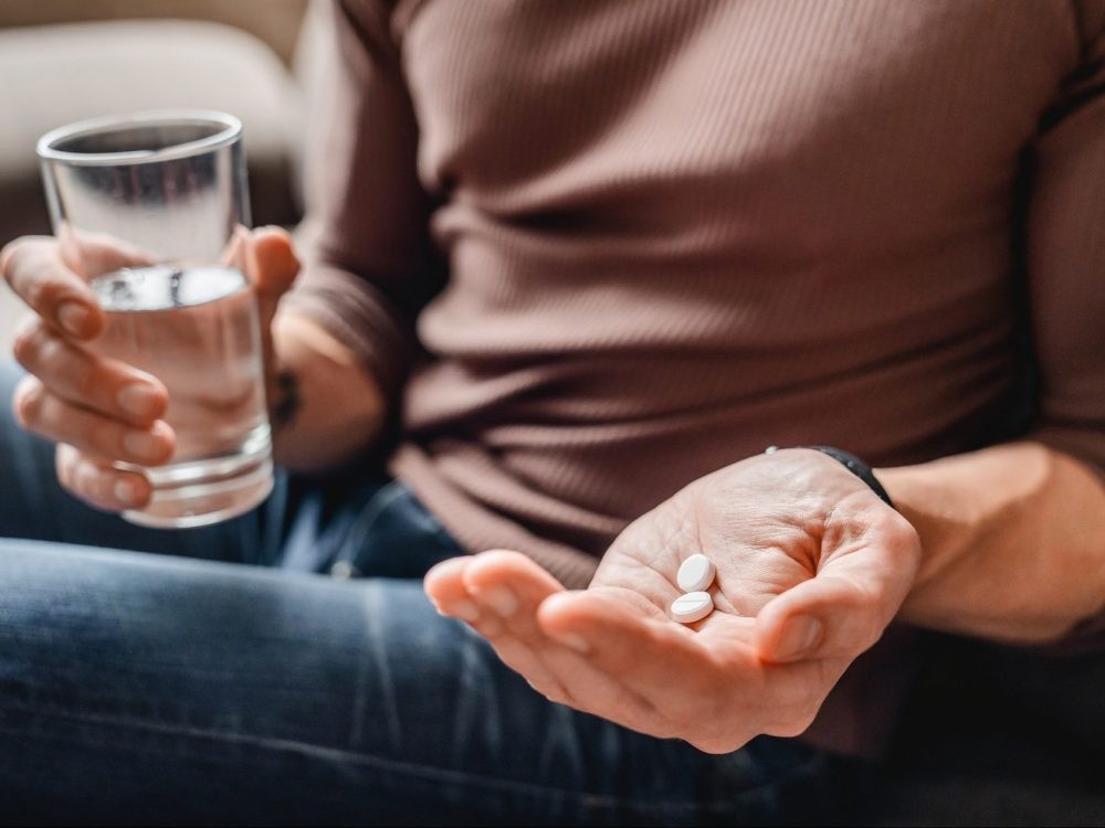 A man takes medicine with water