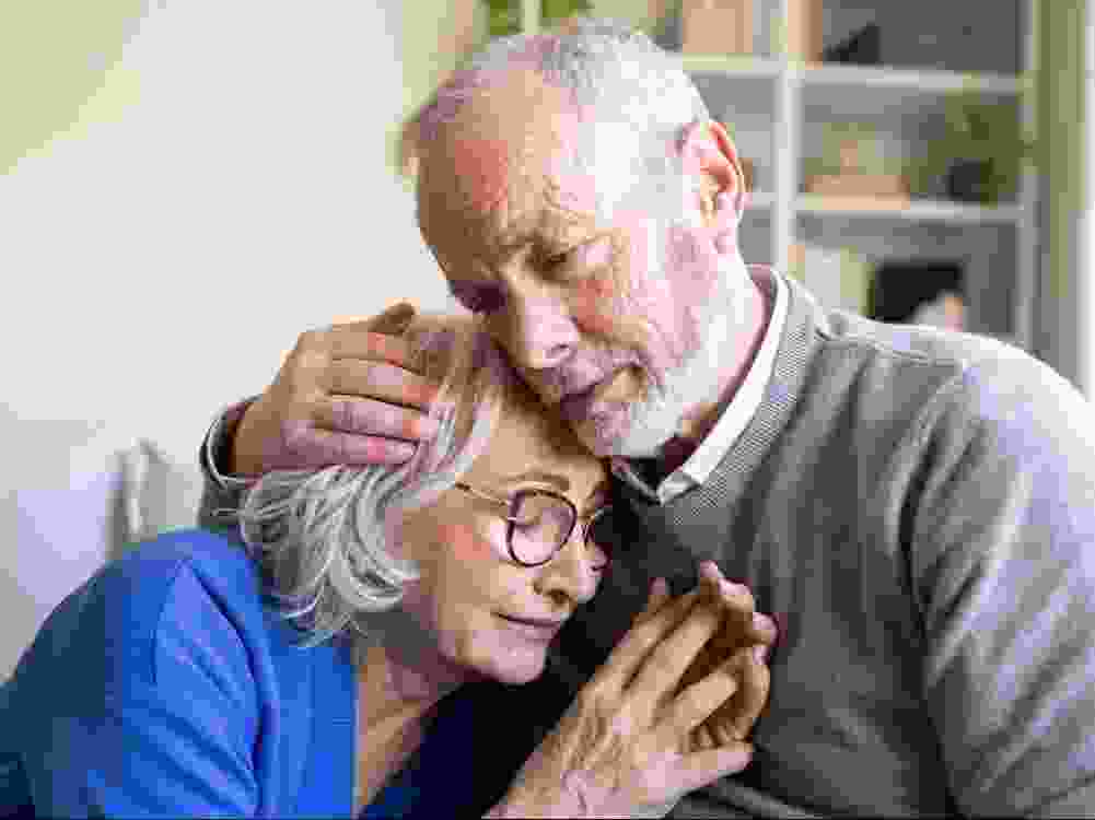 A senior man comforts his wife