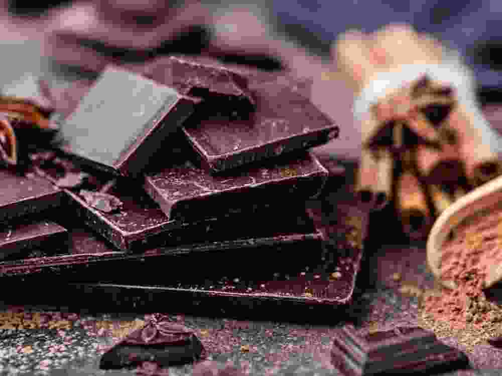 Chocolate bar pieces. Background with chocolate. Sweet food photo concept. The chunks of broken chocolate