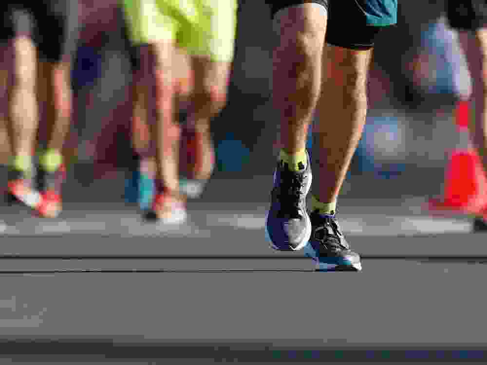 Marathon running race, people feet on city road
