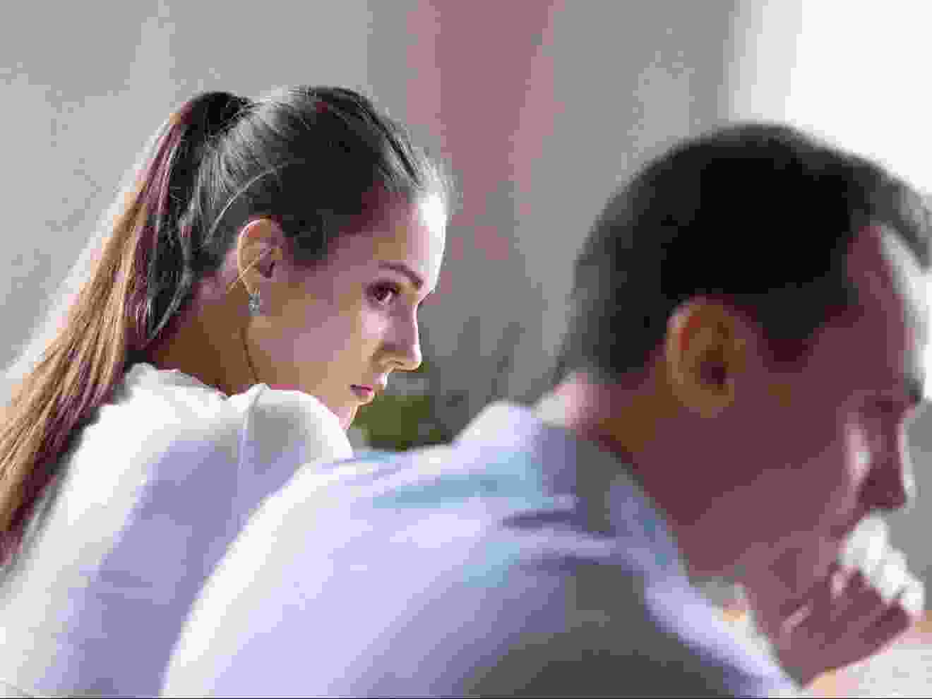 Back view of offended woman looking at stubborn lover.