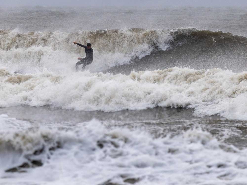 A surfer rides waves created by a Nor'Easter on Sept. 27, 2026 at Rockaway Beach, in the Queens borough of New York City.