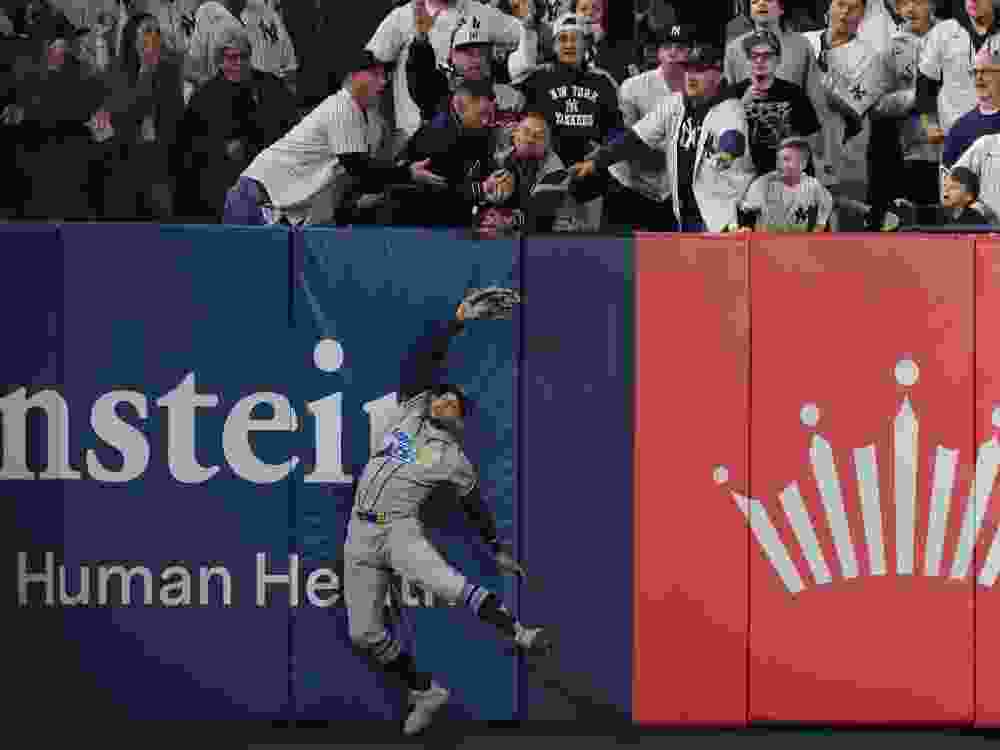 Victor Mesa Jr. of the Tampa Bay Rays is unable to make a catch as fans interfere on a ball hit by Anthony Volpe of the New York Yankees.