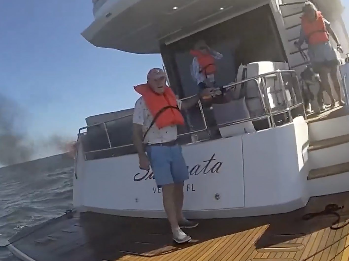 Three boaters and a dog are seen aboard a boat that was on fire off the Florida Gulf Coast.