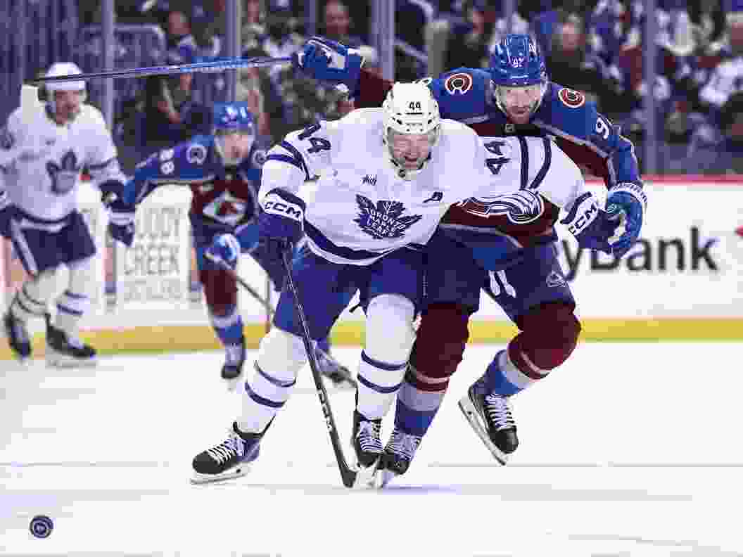 Morgan Rielly #44 of the Toronto Maple Leafs and Gabriel Landeskog #92 of the Colorado Avalanche skate after the puck in the second period at Ball Arena on October 10, 2026 in Denver, Colorado.