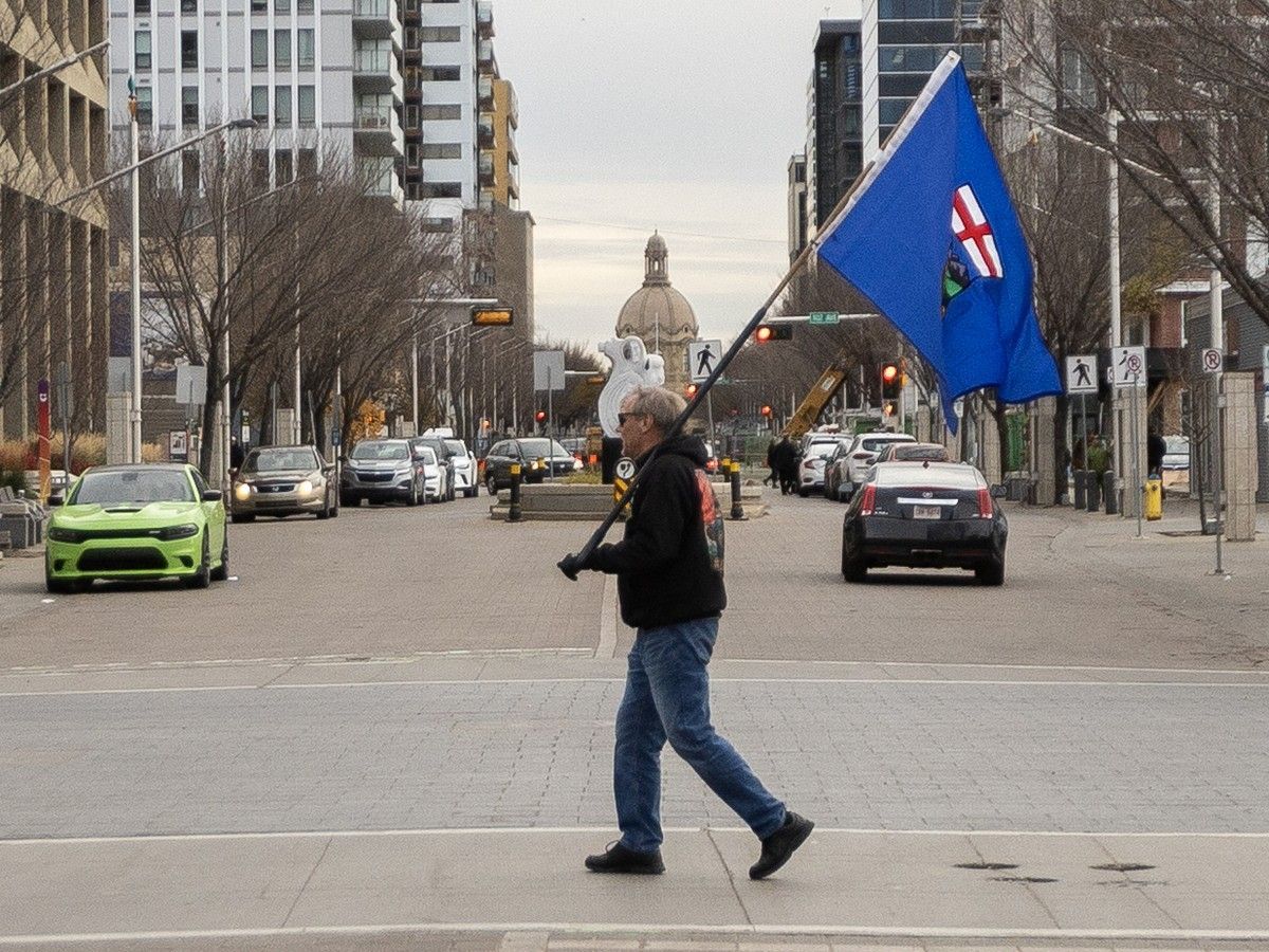 An Alberta separatist supporter carries a flag ahead of the referendum in downtown Edmonton, Alberta, on October 19, 2026.
