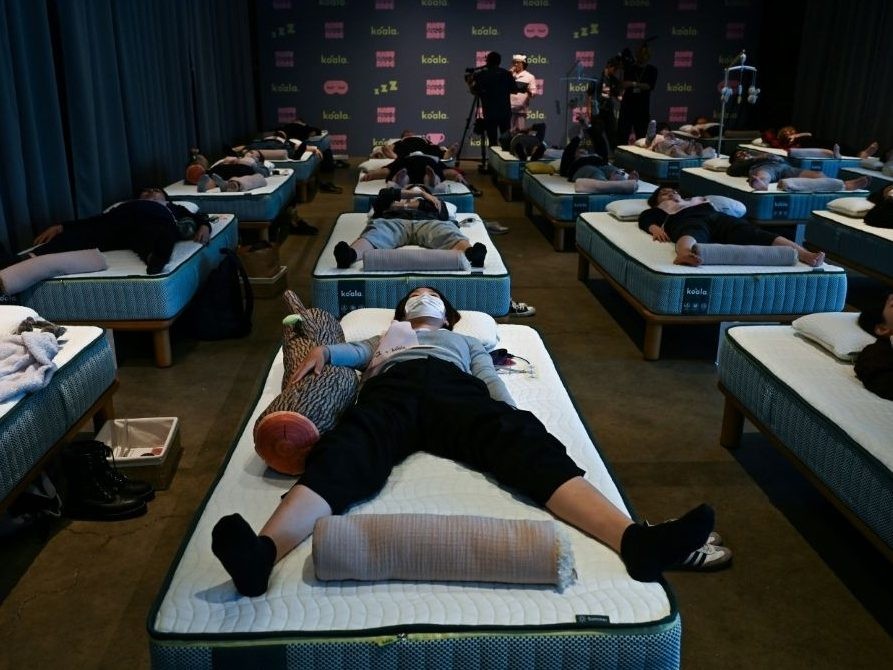 Attendees take part in a sleep competition organised by a mattress brand in Tokyo on October 5, 2026.